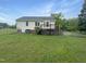 Backyard with a wooden deck, chainlink fence, and lawn at 5749 Stone Crystal Dr, Fuquay Varina, NC 27526