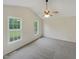 An empty bedroom featuring dark hardwood floors, neutral walls, and natural lighting from the windows at 5749 Stone Crystal Dr, Fuquay Varina, NC 27526