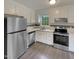 Well-lit kitchen with stainless steel appliances and white cabinets, offering a clean and modern design at 5749 Stone Crystal Dr, Fuquay Varina, NC 27526
