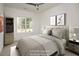 Bright bedroom featuring a ceiling fan, neutral walls, a large window, and a full bookcase at 60 Purslane Dr, Franklinton, NC 27525