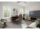 Home office with large screen TV, comfortable seating, and ample natural light from two bright windows at 60 Purslane Dr, Franklinton, NC 27525
