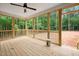 Spacious screened porch with wooden floor and railing overlooking a lush green landscape at 60 Purslane Dr, Franklinton, NC 27525