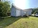 Exterior view of the home with a grassy backyard and a wooden deck at 609 N Magnolia Ave, Dunn, NC 28334