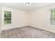 Bright, carpeted bedroom showcasing a window and neutral wall color at 6321 Lymington Dr, Raleigh, NC 27616