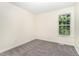 Bright bedroom featuring soft grey carpet and a window providing natural light at 6321 Lymington Dr, Raleigh, NC 27616