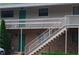 A brick multi-unit building with a staircase leading to the second floor deck at 7 Shepherd Ln # Bldg D, Chapel Hill, NC 27514