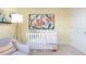 Cozy Bedroom featuring a white crib, comfy chair, and floral artwork for a serene atmosphere at 7384 Michelle Rd, Rocky Mount, NC 27803