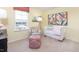 Bright Bedroom with window view, cozy chair, and crib with stylish floral artwork on yellow walls at 7384 Michelle Rd, Rocky Mount, NC 27803