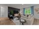 Inviting living room featuring a comfortable sofa, dark accent wall, and large window at 7400 Michelle Rd, Rocky Mount, NC 27803