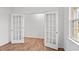 An airy room featuring wood floors, glass-paned double doors, and a large window at 7416 Michelle Rd, Rocky Mount, NC 27803