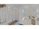 Bright bathroom with double sinks, modern fixtures, glass shower, and views of the neighborhood at 7434 Michelle Rd, Rocky Mount, NC 27803