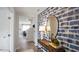 Inviting entryway featuring wood floors, a stylish console table, mirror and a striking patterned accent wall at 7434 Michelle Rd, Rocky Mount, NC 27803