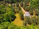 Aerial shot of a secluded home with a fire pit, surrounded by trees and a grassy area at 815 Solitude Pt, Chapel Hill, NC 27516