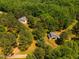 A rural estate featuring a home and barn enveloped by lush trees, providing privacy and a natural setting at 815 Solitude Pt, Chapel Hill, NC 27516