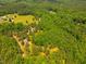 Scenic aerial view of a lush tree-filled property, featuring a long driveway and expansive green space at 815 Solitude Pt, Chapel Hill, NC 27516