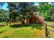 Barn featuring a large doorway, a wooden staircase, and lush greenery; fenced in for privacy and a rural charm at 815 Solitude Pt, Chapel Hill, NC 27516
