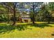 Exterior view of barn with fencing surrounded by trees and green grass at 815 Solitude Pt, Chapel Hill, NC 27516