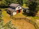 Aerial view of barn with fenced area and sliding wood doors and an attached lean-to for additional shelter at 815 Solitude Pt, Chapel Hill, NC 27516