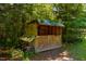 Rustic outbuilding surrounded by lush greenery, perfect for storage or a hobby space at 815 Solitude Pt, Chapel Hill, NC 27516