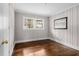 Cozy bedroom with wood floors, decorative wainscoting, and a window providing ample natural light at 829 Burton St, Rocky Mount, NC 27803