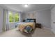 Bright bedroom featuring a large window with beautiful views and carpet flooring at 8509 Oneal Rd, Raleigh, NC 27613