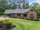 Charming brick home featuring a landscaped front yard and an attached carport for convenient parking at 8509 Oneal Rd, Raleigh, NC 27613