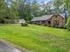 Spacious front yard with mature trees and shrubs showcasing the home's curb appeal at 8509 Oneal Rd, Raleigh, NC 27613