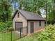 Detached garage with ample storage space surrounded by lush greenery and a fence at 8509 Oneal Rd, Raleigh, NC 27613