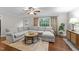 Bright living room with hardwood floors, a large sectional sofa, and a view of the outdoors at 8509 Oneal Rd, Raleigh, NC 27613