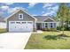 Beautiful home with a two-car garage, gray siding, manicured lawn, and a charming front entrance at 8615 Kenridge Ln, Fuquay Varina, NC 27526