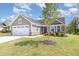 Home exterior with a two-car garage, a well-kept lawn, and a classic craftsman-style front entrance at 8615 Kenridge Ln, Fuquay Varina, NC 27526