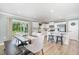 Bright kitchen and dining area with white cabinets, stainless appliances, an island with stools, and sliding glass doors at 8615 Kenridge Ln, Fuquay Varina, NC 27526
