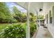 Covered back porch with lush landscaping and serene views at 1000 Winona Rd, Raleigh, NC 27609