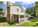 Back of home with brick chimney and screened porch with view of well-manicured lawn at 1000 Winona Rd, Raleigh, NC 27609