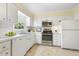 Well-lit kitchen boasting stainless steel appliances, ample counter space, and classic white cabinets at 1000 Winona Rd, Raleigh, NC 27609
