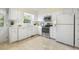 Bright kitchen with white cabinets, stainless steel appliances, and a window overlooking the backyard at 1000 Winona Rd, Raleigh, NC 27609