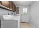 Laundry room with a washer, dryer, and overhead cabinets at 1000 Winona Rd, Raleigh, NC 27609