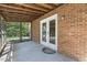 Covered patio with brick wall and screened window at 1000 Winona Rd, Raleigh, NC 27609