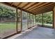 Enclosed outdoor patio featuring concrete floor and exposed wooden beams with backyard view at 1000 Winona Rd, Raleigh, NC 27609