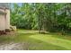 Expansive backyard with lush green grass, mature trees, and wooded views at 1003 Wicksteed Ct, Apex, NC 27502