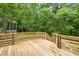 New wooden deck overlooking lush greenery provides serene outdoor space for relaxation at 1003 Wicksteed Ct, Apex, NC 27502