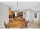 The dining room features an elegant chandelier, a wooden dining table and chairs, and an open view into the kitchen at 1003 Wicksteed Ct, Apex, NC 27502