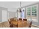 The dining room features an elegant chandelier, a wooden dining table and chairs, and lots of natural light at 1003 Wicksteed Ct, Apex, NC 27502