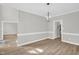 This dining room offers ample natural light, modern lighting fixture, and neutral paint with views to other rooms at 1003 Wicksteed Ct, Apex, NC 27502
