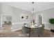 Elegant dining room with a round table, modern lighting, and a view into the living room at 1003 Wicksteed Ct, Apex, NC 27502