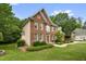 Stunning home exterior with brick, neutral siding, manicured lawn, and mature trees offering great curb appeal at 1003 Wicksteed Ct, Apex, NC 27502