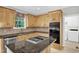 This well-appointed kitchen features wood cabinets, stainless appliances, a gas cooktop, and a charming window with valance at 1003 Wicksteed Ct, Apex, NC 27502
