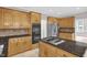 This updated kitchen features wooden cabinets, stainless steel appliances, a gas stovetop, and a granite countertop at 1003 Wicksteed Ct, Apex, NC 27502