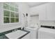 Well-lit laundry room with overhead cabinets, utility sink, and washer and dryer at 1003 Wicksteed Ct, Apex, NC 27502