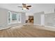 Open-concept living area featuring wood-look floors, ceiling fan, bay window, and seamless access to the kitchen at 1003 Wicksteed Ct, Apex, NC 27502